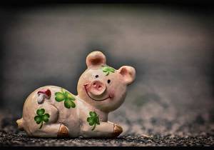 Pig figurine with cloverleaves as a symbol of happiness