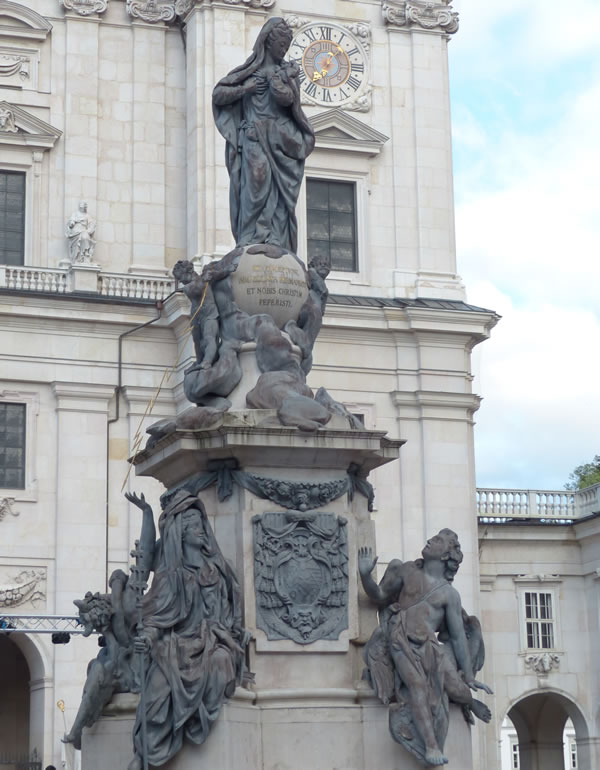 Sculpture of the Virgin Mary and her coronation on the globe in Salzburg, Cathedral Square. There are also figures of an angel, Satan, church and wisdom on the pedestal.